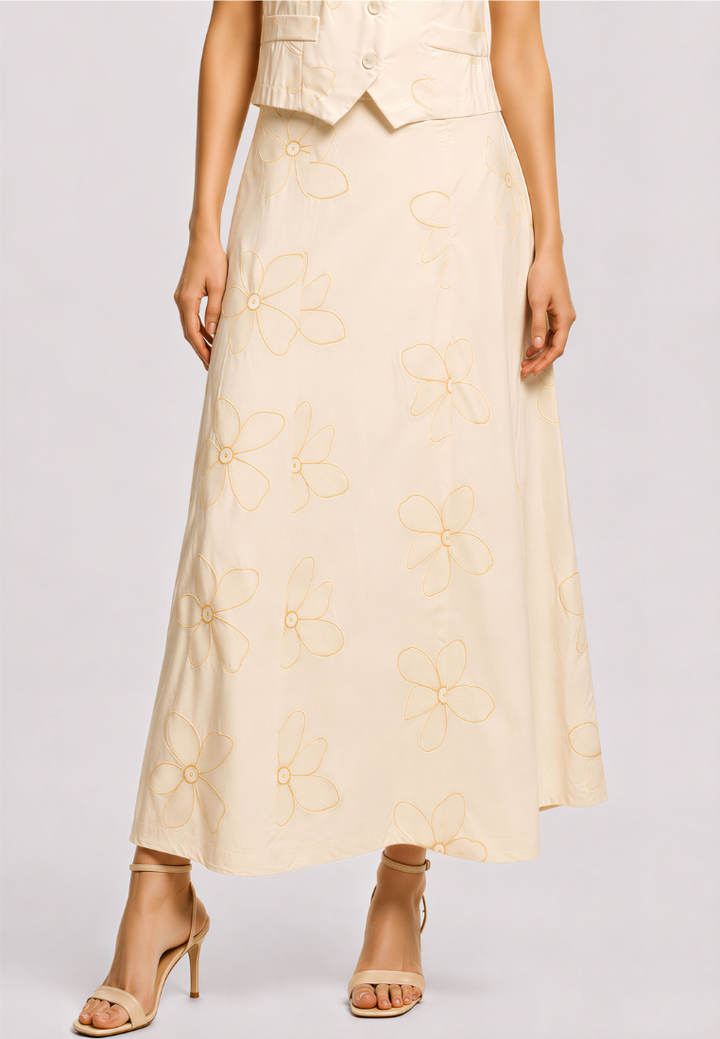 Woman wearing Love Knot Myra beige floral embroidered A-line midi skirt, styled with the matching Lena vest and heels